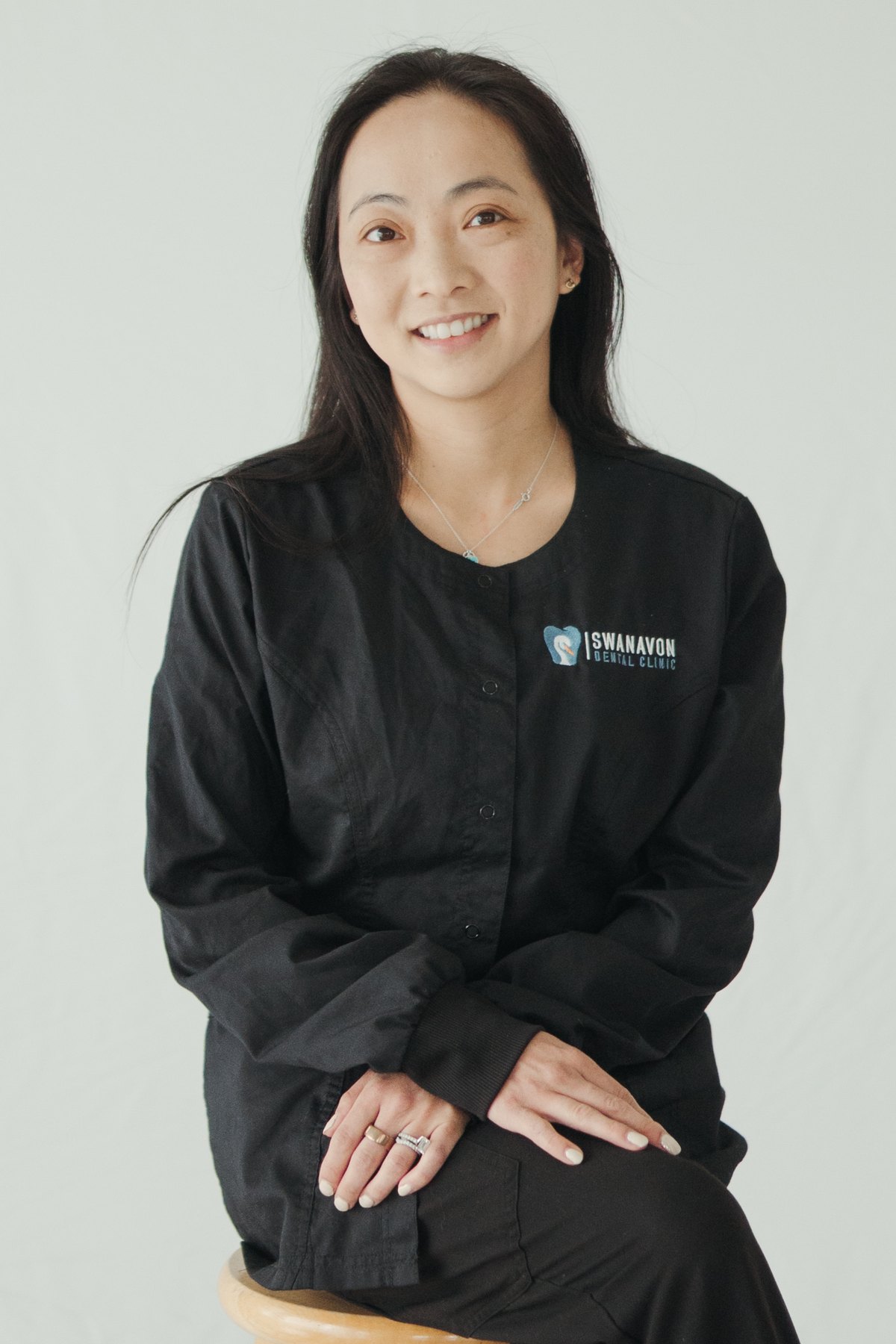 Dr. Tammy Chu smiling, wearing her black clinical uniform